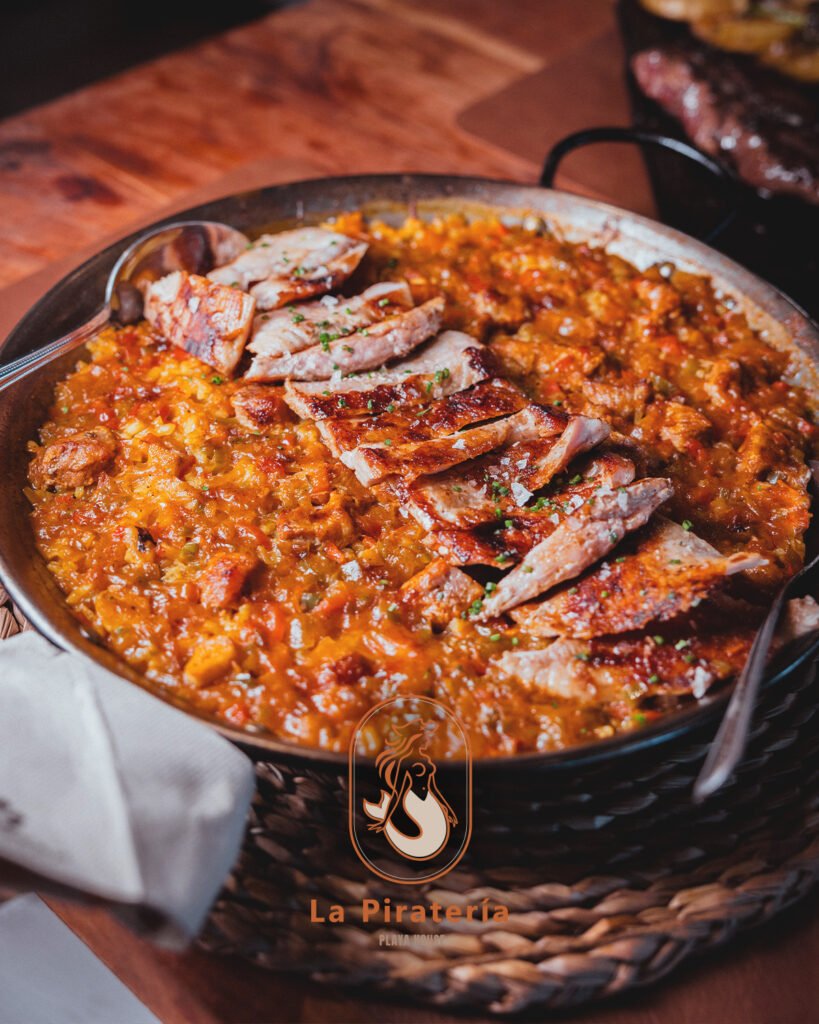 Paella de secreto ibérico de La Piratería, con el secreto laminado sobre el arroz